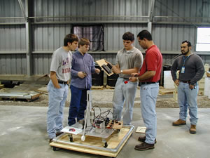 Travis, Matt, Randolph, Mr. Sanchez, and Mr. Sanchez work on the electronics